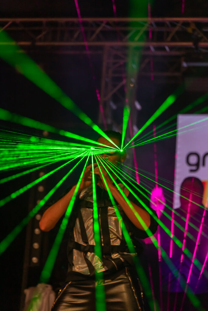 Artiste au milieu de faisceaux laser verts