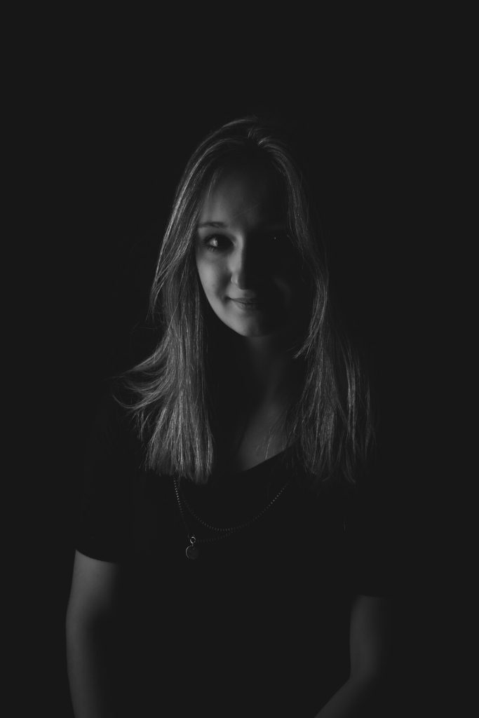 Portrait d’Océane en noir et blanc dans la pénombre