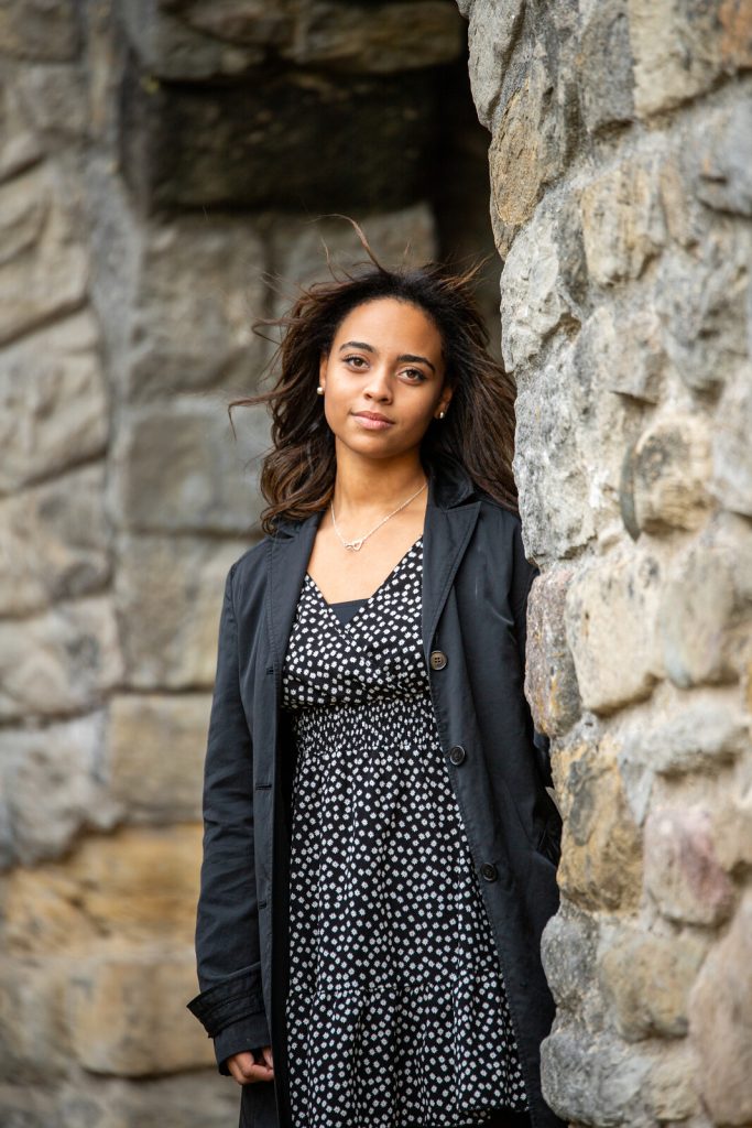 Shanna devant un mur de pierre