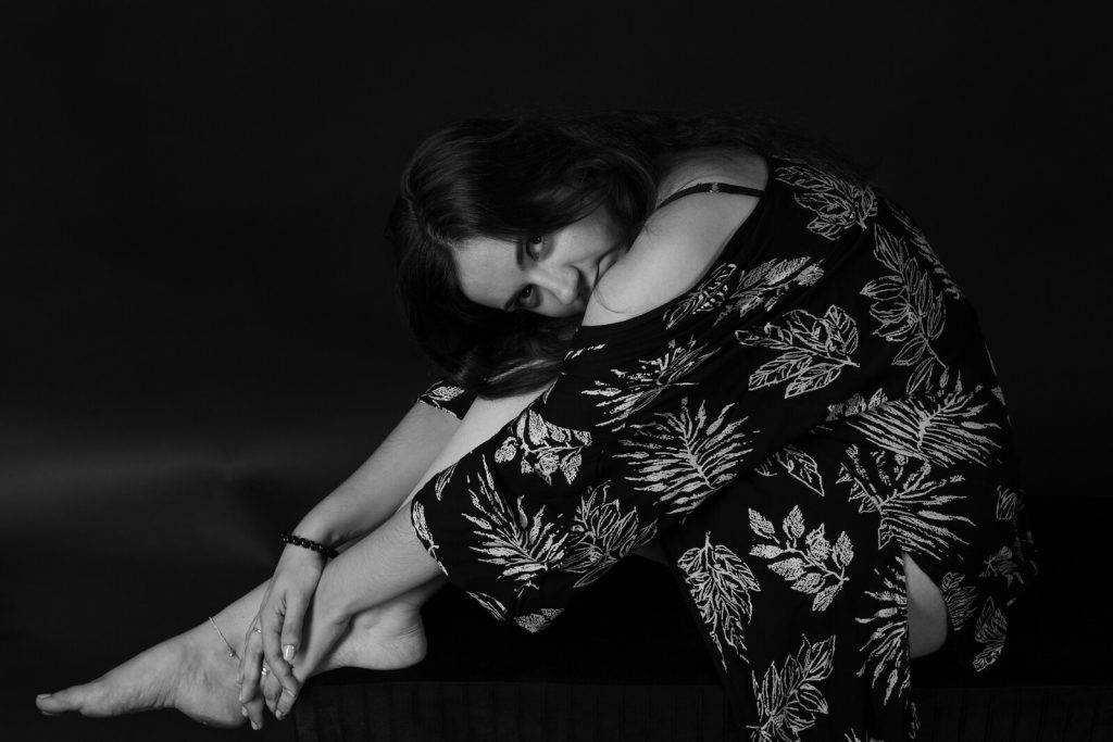 Estelle assise, portrait en noir et blanc à la lumière douce